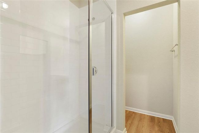 Bathroom with a stall shower, wood finished floors, and baseboards | Image 15