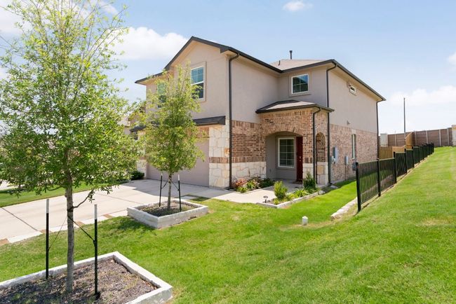 Back of house with concrete driveway, stone siding, a garage, and stucco siding | Image 4