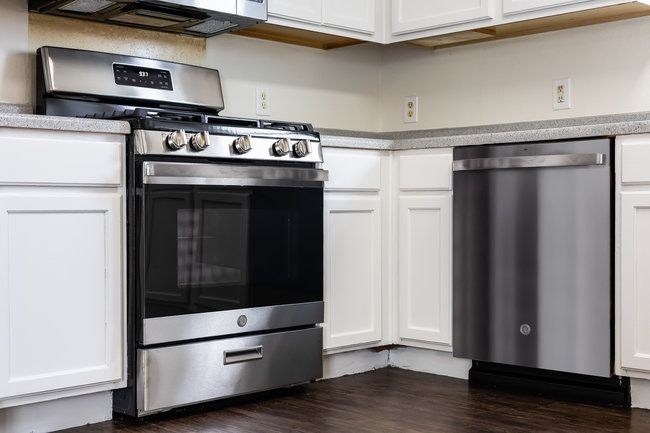Kitchen with appliances with stainless steel finishes, white cabinetry, and light countertops | Image 15