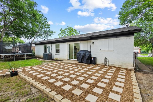 Back of property featuring a trampoline, brick siding, a patio, and fence | Image 12