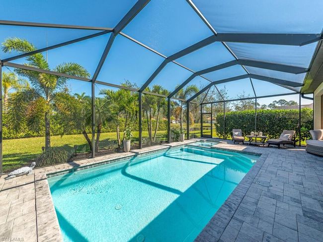 View of pool with a yard, a lanai, a patio area, and a pool with connected hot tub | Image 11