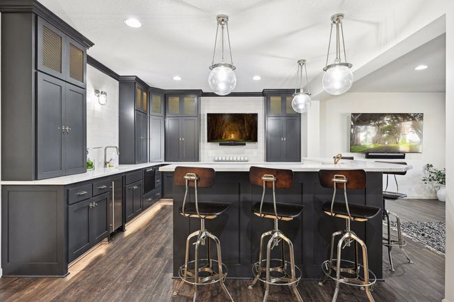 Lower level bar is gorgeous and functional with a convection oven/microwave, dish washer, ice maker, beverage fridges, dual temp wine fridge and plenty of countertop space to have an amazing spread for your next gathering! | Image 53