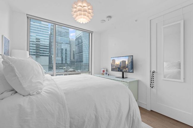 Bedroom with floor to ceiling windows and wood finished floors | Image 15