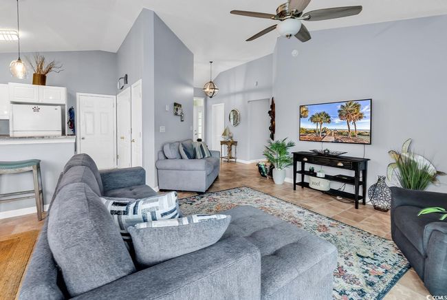Living room featuring high vaulted ceiling, ceiling fan, and light tile patterned flooring | Image 4