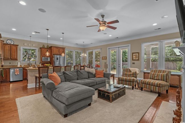 Living area with plenty of natural light, wood finished floors, recessed lighting, french doors, and ornamental molding | Image 13