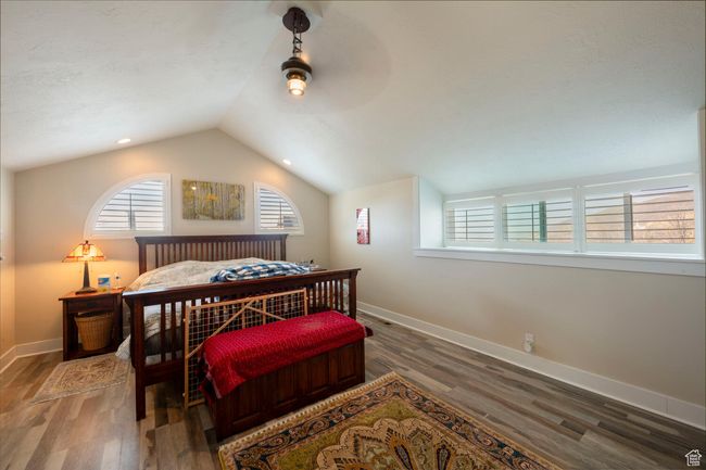 Bedroom with baseboards, vaulted ceiling, ceiling fan, and wood finished floors | Image 26