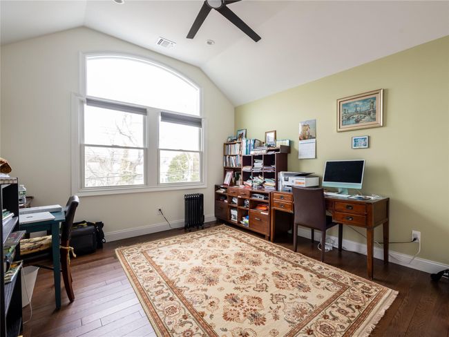 Home office featuring vaulted ceiling, hardwood / wood-style floors, ceiling fan, and visible vents | Image 15
