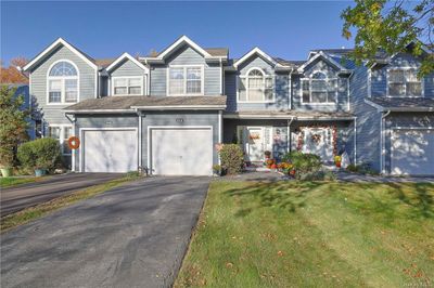 Townhome / multi-family property featuring a garage and a front lawn | Image 1