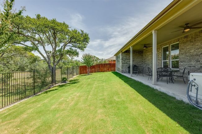 Fenced backyard with ceiling fan and a patio | Image 25