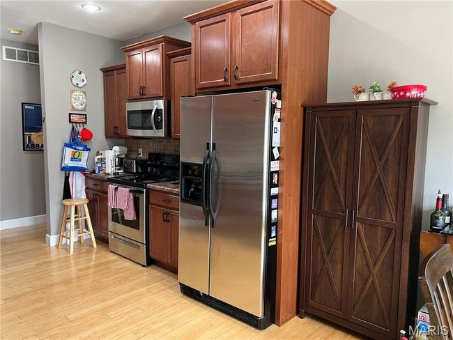 Kitchen featuring appliances with stainless steel finishes, backsplash, light wood-style flooring, and recessed lighting | Image 7