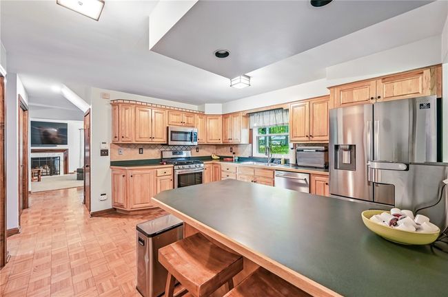 Beautiful kitchen with a center island, offering both workspace and seating. | Image 15