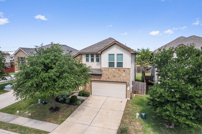 View of front of home with stone siding, a garage, and concrete driveway | Image 8