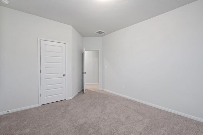 Empty room with light colored carpet, visible vents, and baseboards | Image 28
