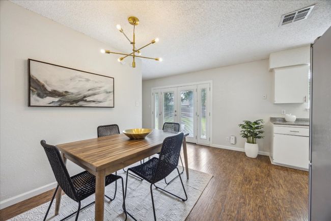 Dining room with a chandelier, french doors, wood finished floors, and a textured ceiling | Image 13