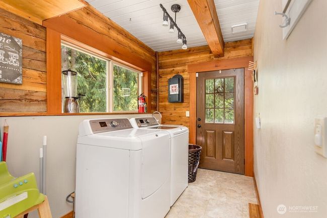 Utility/laundry room walks out onto wrap around deck to front of home. | Image 8