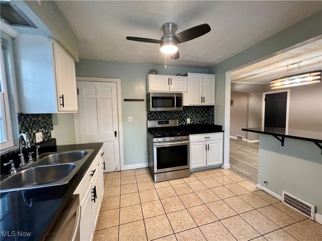 Kitchen with white cabinets and stainless steel appliances | Image 6