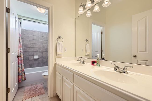 Upstairs bathroom featuring double vanity, shower / bath combination, tile floor | Image 20