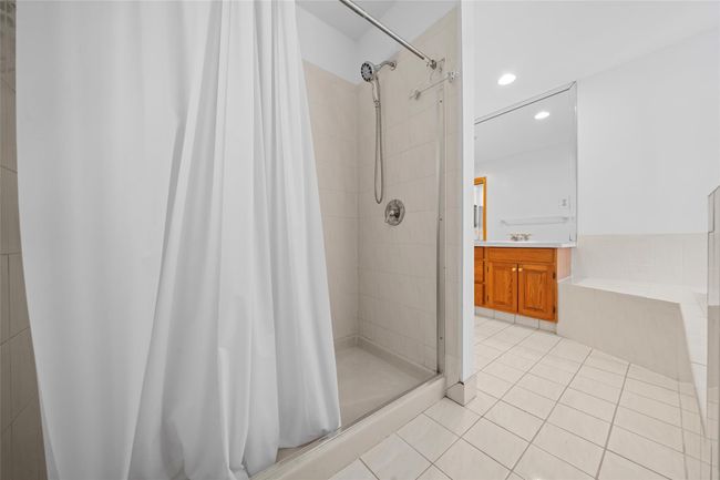 Bathroom with a garden tub, a stall shower, vanity, tile patterned flooring, and recessed lighting | Image 29