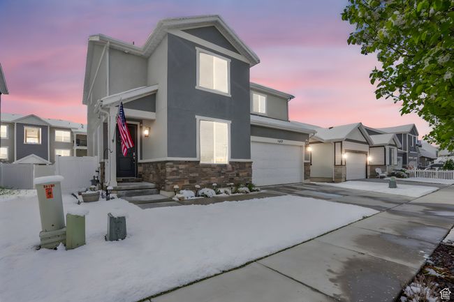 View of front of home featuring driveway, stone siding, fence, an attached garage, and stucco siding | Image 35