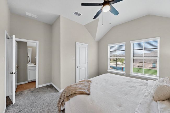 Bedroom featuring lofted ceiling, carpet, ceiling fan, and ensuite bathroom | Image 24