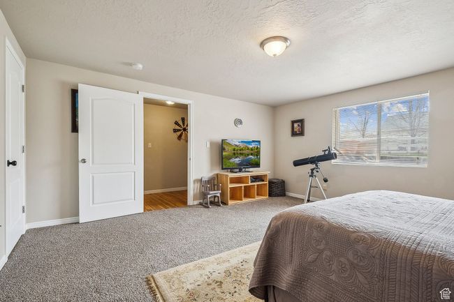 Carpeted bedroom featuring a textured ceiling and baseboards | Image 52