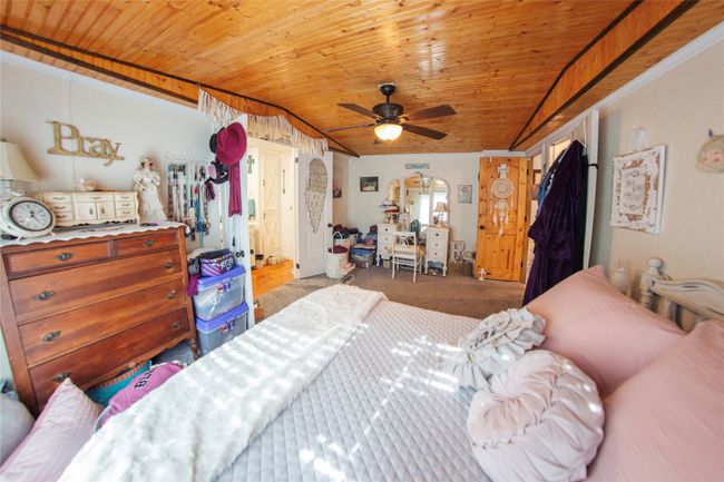 Carpeted bedroom featuring ceiling fan and wooden ceiling | Image 8