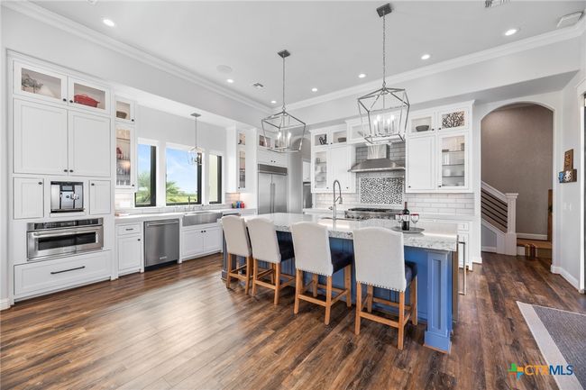 Kitchen with Double Sinks, Large Island with Breakfast Bar and Sink, Double Oven Range, Under Cabinet Lights, and Lighted Glass Cabinets | Image 6