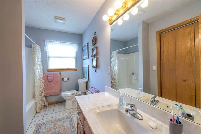 Bathroom with vanity, tile patterned floors, shower / tub combo, and a textured ceiling | Image 31