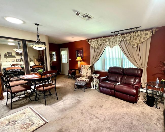Living room with carpet floors and a baseboard heating unit | Image 8