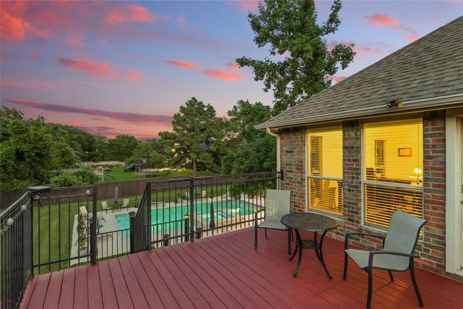 Balcony view overlooking a fenced side and back yard, a pool with connected hot tub, and a patio area | Image 37