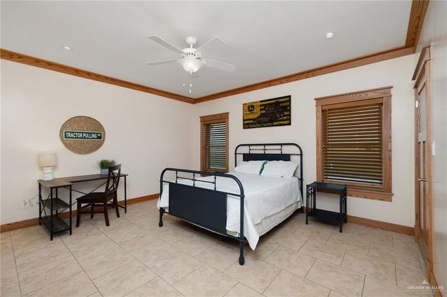 Bedroom featuring ceiling fan, ornamental molding, and light tile patterned flooring | Image 13