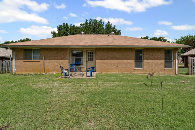 Rear view of house with brick siding, a patio, and roof with shingles | Image 19