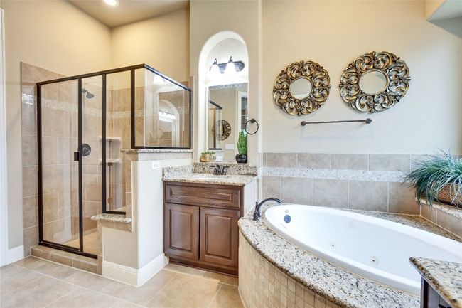 Owners full bathroom featuring a stall shower, a tub with jets, vanity, and large tile patterned floors | Image 26