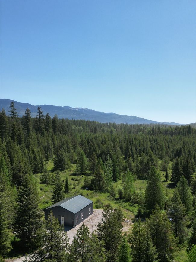 View of mountain backdrop with a heavily wooded area | Image 26