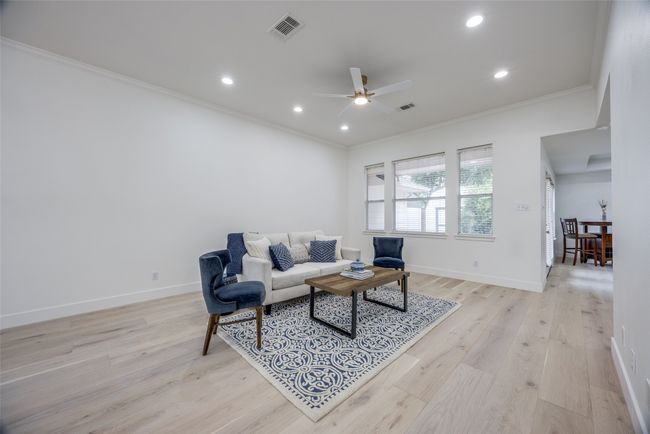 Living area featuring crown molding, a ceiling fan, light wood-style flooring, and recessed lighting | Image 6