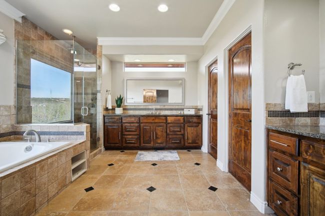 Bathroom featuring a stall shower, recessed lighting, crown molding, a bath, and vanity | Image 22