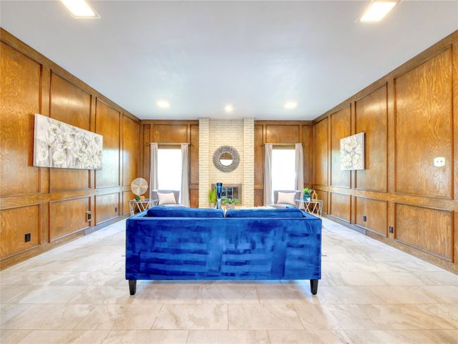 Living area featuring a floor to ceiling brick fireplace | Image 7
