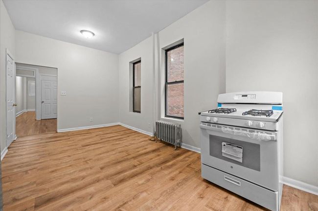 Kitchen featuring gas range gas stove, radiator heating unit, and light wood finished floors | Image 13