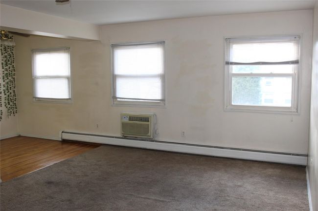 Carpeted featuring a wall mounted air conditioner, baseboard heating | Image 10