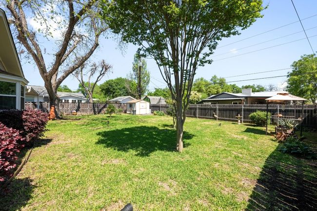 View of yard featuring a fenced backyard, a shed, and an outdoor structure | Image 27