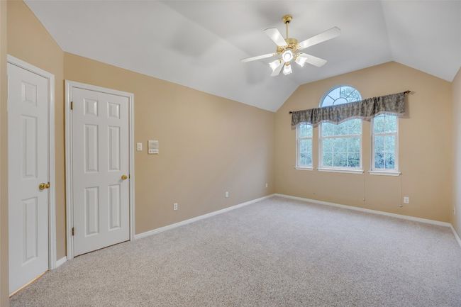 Carpeted empty room featuring ceiling fan and vaulted ceiling | Image 31