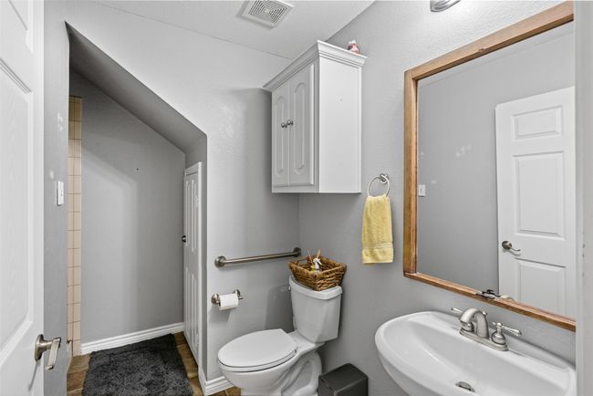 Second downstairs full bathroom featuring a sink and tile patterned flooring | Image 7