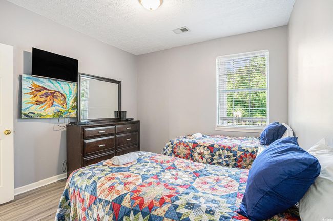 Bedroom featuring wood finished floors and a textured ceiling | Image 17
