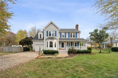 View of front of house with a garage, covered porch, and a front lawn | Image 1