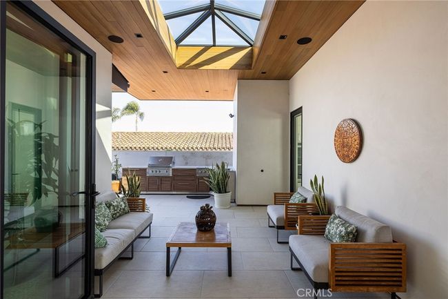 Built in BBQ with porcelain counters, wood-grain metal cabinetry, dual burner, outdoor sink and storage. | Image 28