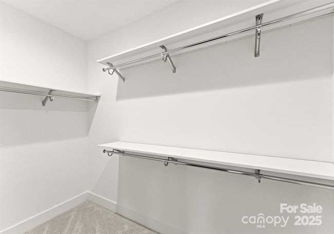 Primary walk in closet with wood shelving. | Image 17
