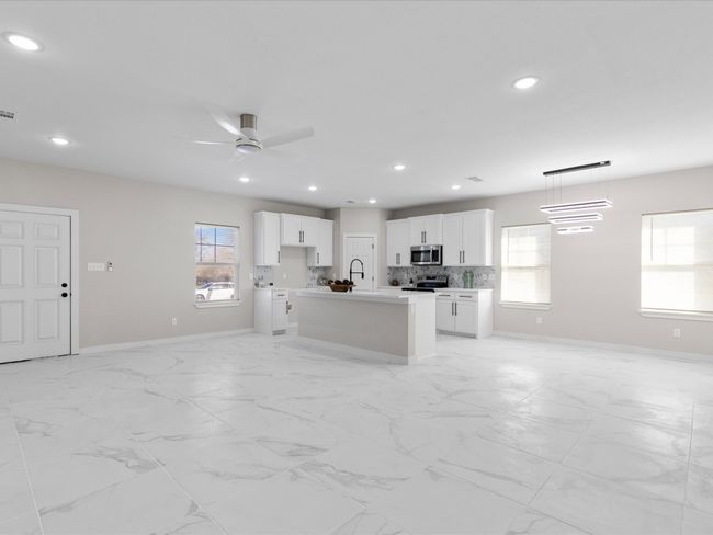 Kitchen featuring an island with sink, backsplash, open floor plan, recessed lighting, and stainless steel appliances | Image 7