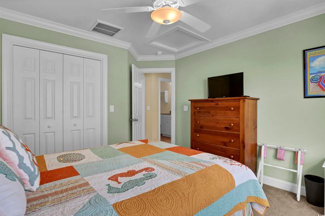 Bedroom featuring attic access, a closet, crown molding, carpet, and a ceiling fan | Image 22