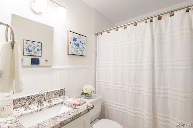 Updated hall bath with tub/tiled shower surround, new vanity, and marble floor | Image 24