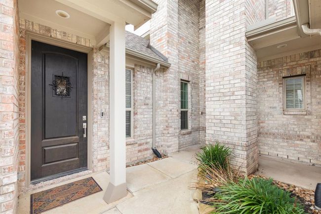 inviting entryway complemented by a neatly trimmed garden offering a warm welcome to the home. | Image 5